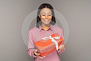 Excited young woman hold gift box for christmas or new year holiday. Happy female looking at present