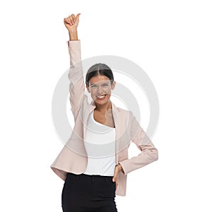 Excited young woman holding hand up and making thumbs up gesture