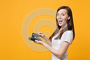 Excited young woman holding wireless modern bank payment terminal to process and acquire credit card payments isolated