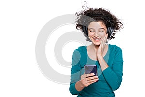 Excited young woman looking at her mobile phone smiling. Woman reading text message on her phone.