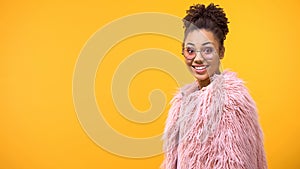 Excited young woman in pink eyeglasses looking camera, amazement, happiness