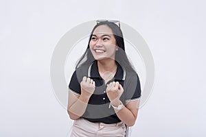 An excited young woman pumping both her fists, giddy with anticipation and energy. Isolated on a white backdrop photo