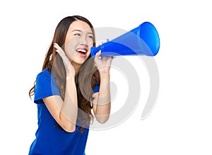 Excited young woman shout with loudspeaker