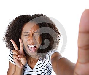 Excited young woman showing peace sign in selfie