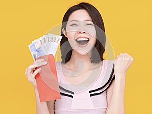 Excited young woman showing the red envelope and money.Happy chinese new year concept