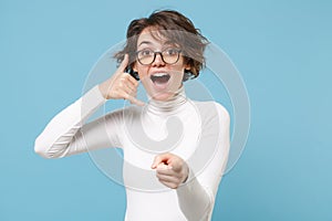 Excited young woman in white clothes, glasses isolated on pastel blue background. People lifestyle concept. Mock up copy