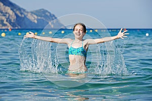 Exciting girl with sea water splashes