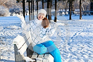 Exciting young woman with hands up at winter park