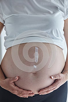 Exclamation mark painted with body cream on pregnant woman`s belly