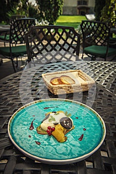 Exclusive cheese mousse with marinated walnuts and golden beetroot served on turquoise plate, top gastronomy
