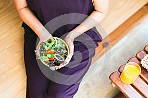 Excretory good system concept,Woman hand holding and eating healthy salad for breakfast in the morning