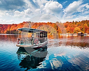 Excursion ship on the lake. Splendid autumn view of Plitvice lake. Colorful morning landscape of Croatia, Europe. Traveling concep
