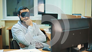 Executive with blindfold sleeping at work
