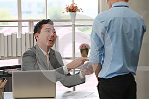 Executive boss Asian businessman in suit holding paperwork and blaming young employee with anger and serious gesture look like he