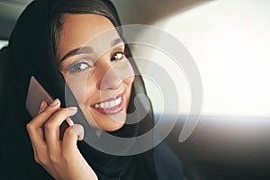 Executive business demands executive travel. Shot of a young muslim businesswoman using her phone while traveling in a