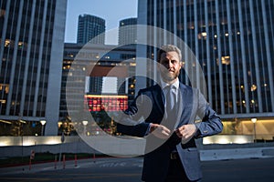 Executive businessman. Portrait of ceo near modern office in suit. Happy leader standing in front of company building.