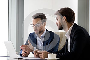 Executive businessmen colleagues working together helping in teamwork on laptop