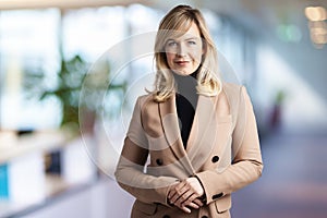 Executive businesswoman with blond hair looking at camera and smiling