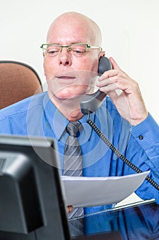 Executive comparing computer and written notes