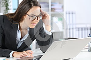 Executive with eyesight problem reading on laptop at office
