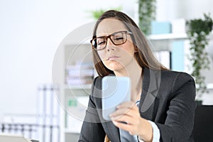 Executive with eyesight problem reading on phone at office