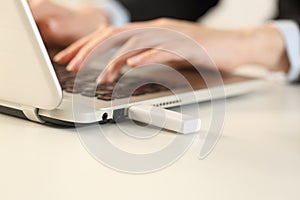 Executive hands typing on laptop with pendrive connected photo