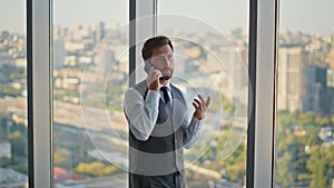 Executive having phone conversation in panoramic office. Bearded lawyer manager