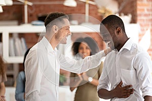 Executive manager congratulating African American employee at meeting