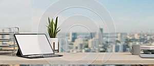 Executive office desk , close-up, tablet blank screen mockup over blurred city view