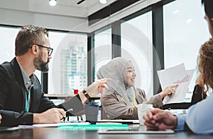 The executive officer is looking at her presentation about finance graph of the company. Muslim female officer present an analysis