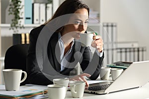 Executive overworking needing caffeine at night at office photo