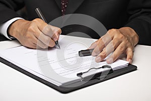 Executive sitting at a table and signing a document