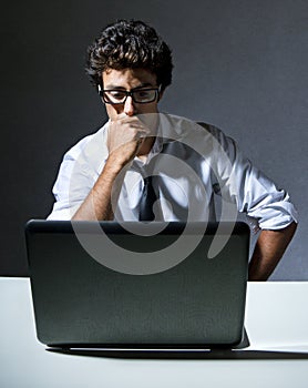 Executive thinking in front of his laptop