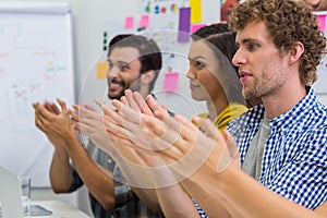 Executives applauding during presentation in conference room