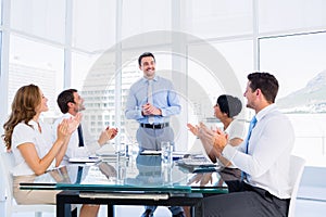 Executives clapping around conference table