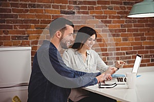 Executives discussing over laptop at desk