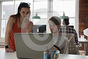 Executives discussing over laptop in office