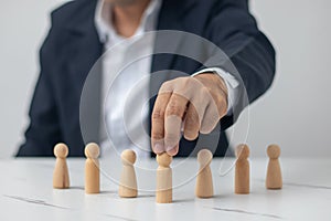 Executives hand in hand with wooden dolls. (organization management concept