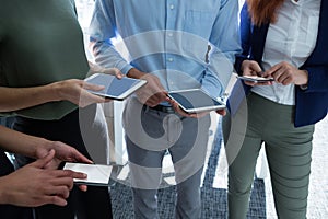 Executives using mobile phone and digital tablet in the office