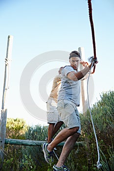 Exercise and adventure. Shot of men going through an obstacle course at bootcamp.