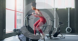 Exercise bike, cardio and girl cycling for sports fitness, athlete marathon training or high energy body workout. Gym
