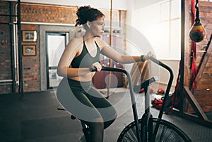 Exercise bike, fitness and woman at gym for workout, cardio training and cycling for energy, balance and lose weight