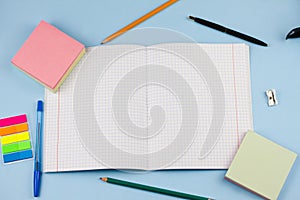 Exercise book with school supplies on a blue background.