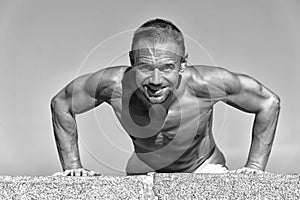 Daily exercise concept. Push ups challenge. Man motivated workout outdoors. Sportsman improves his strength by push up photo
