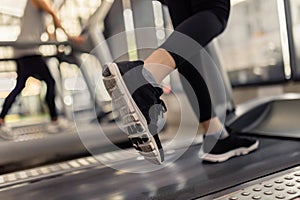 Exercise concept The two treadmills being run by the two players that one wearing black sneakers while another one putting on