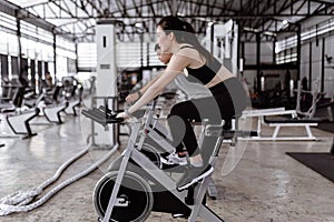 Exercise concept The well-shaped lady and the muscular man being entertaining having small chat while riding the exercise bike