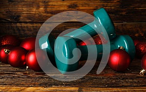 Exercise equipment as a Christmas gift idea. Gym dumbbells with baubles decorations.