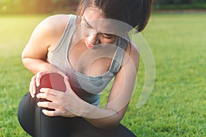 Exercise and healthy concept, Young woman asian have accident knee twist sprain in sport exercise jogging, Selective focus