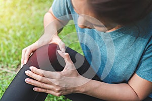 Exercise and healthy concept, Young woman asian have accident knee twist sprain in sport exercise jogging, Selective focus
