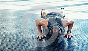 Exercise is a positive way of changing yourself. a young man doing push ups in a gym.